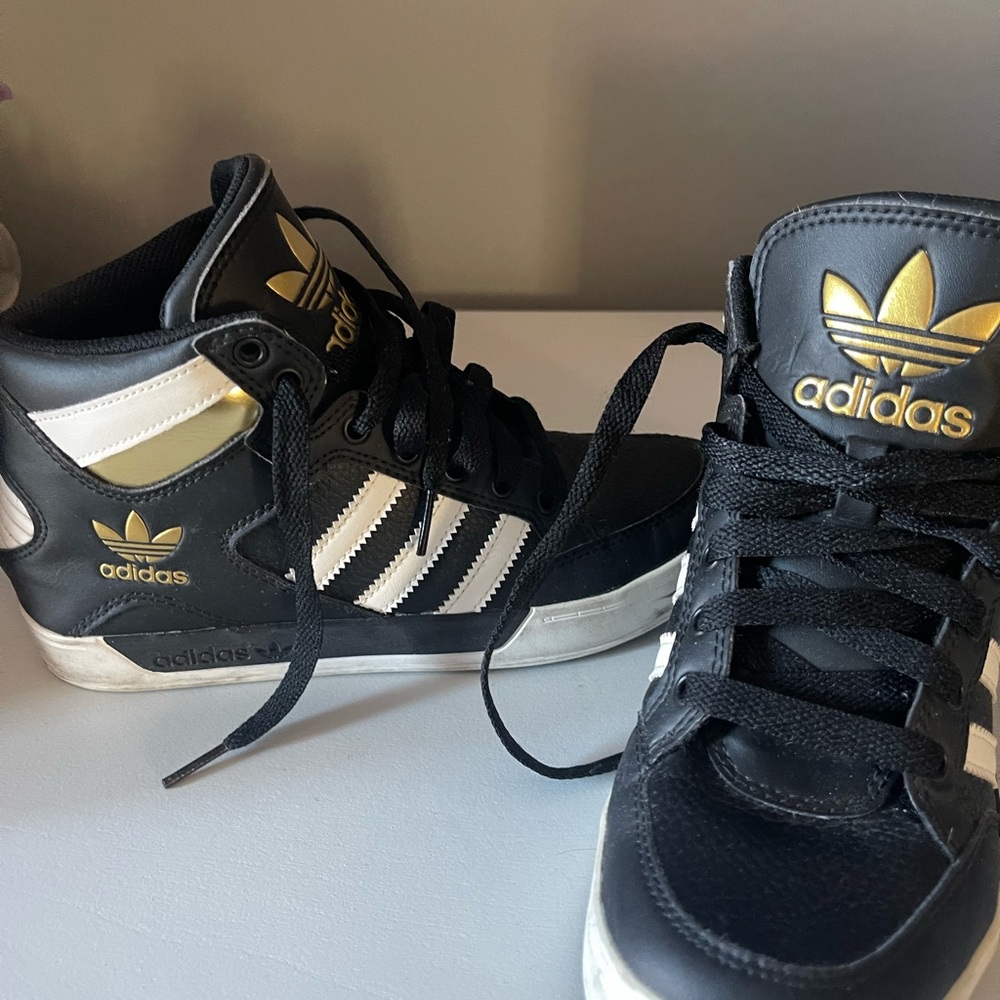 This is a pair of Adidas Hard Court High "Black White Gold" sneakers